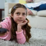 Fille changeant de chaîne télé
